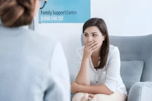 Worried woman speaking with a counsellor at a family support centre, seeking emotional help and guidance in Manchester.